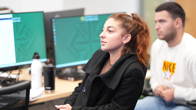 student sits in front of computers at the silk investment lab
