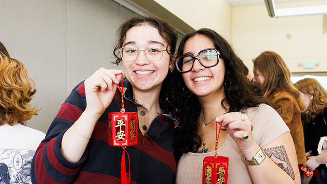 students hold up small red lanterns at lunar new year