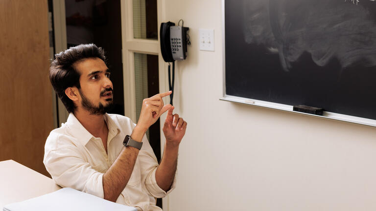 graduate student gestures with hands while speaking in class
