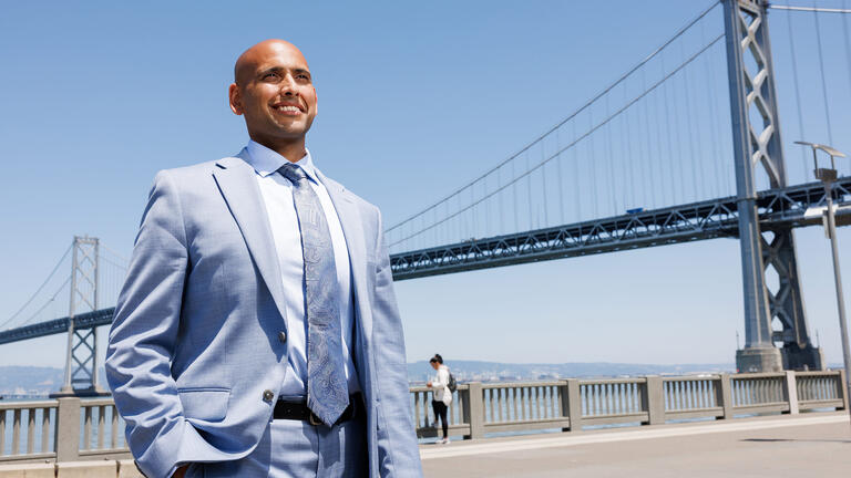 Shounak Dharap stands in front of the San Francisco Bay Bridge