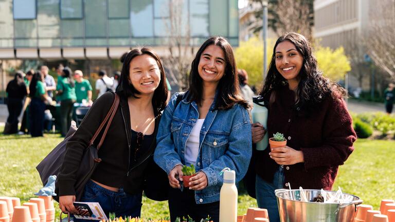Three students smiling in Gleeson Plaza