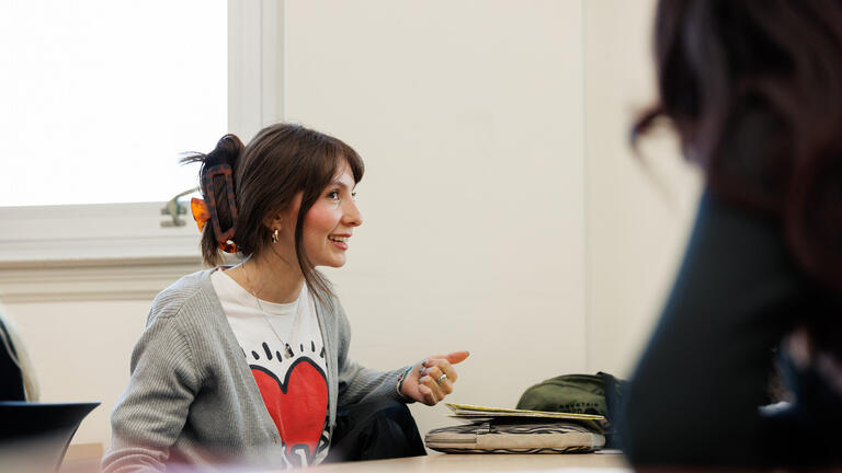 student sitting in classroom smiling