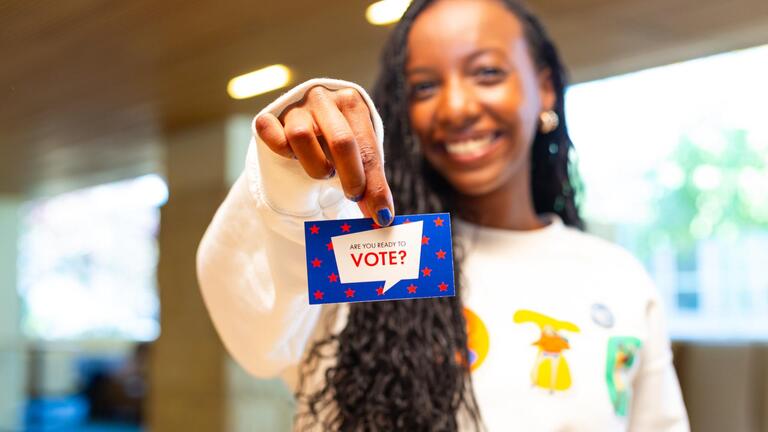 student holding a are you ready postit card