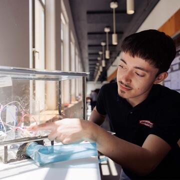 Engineering student pointing at wires in a box