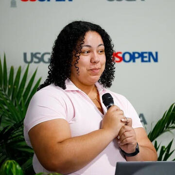 Lexis Withers holding microphone, speaking at USGA/US Open event