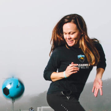 Brianna Russell MA '12 juggles a soccer ball with her feet