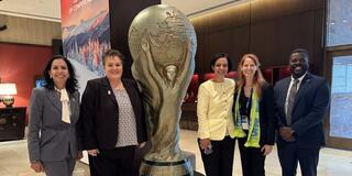 Meghna Tare, right of display trophy, and World Cup colleagues