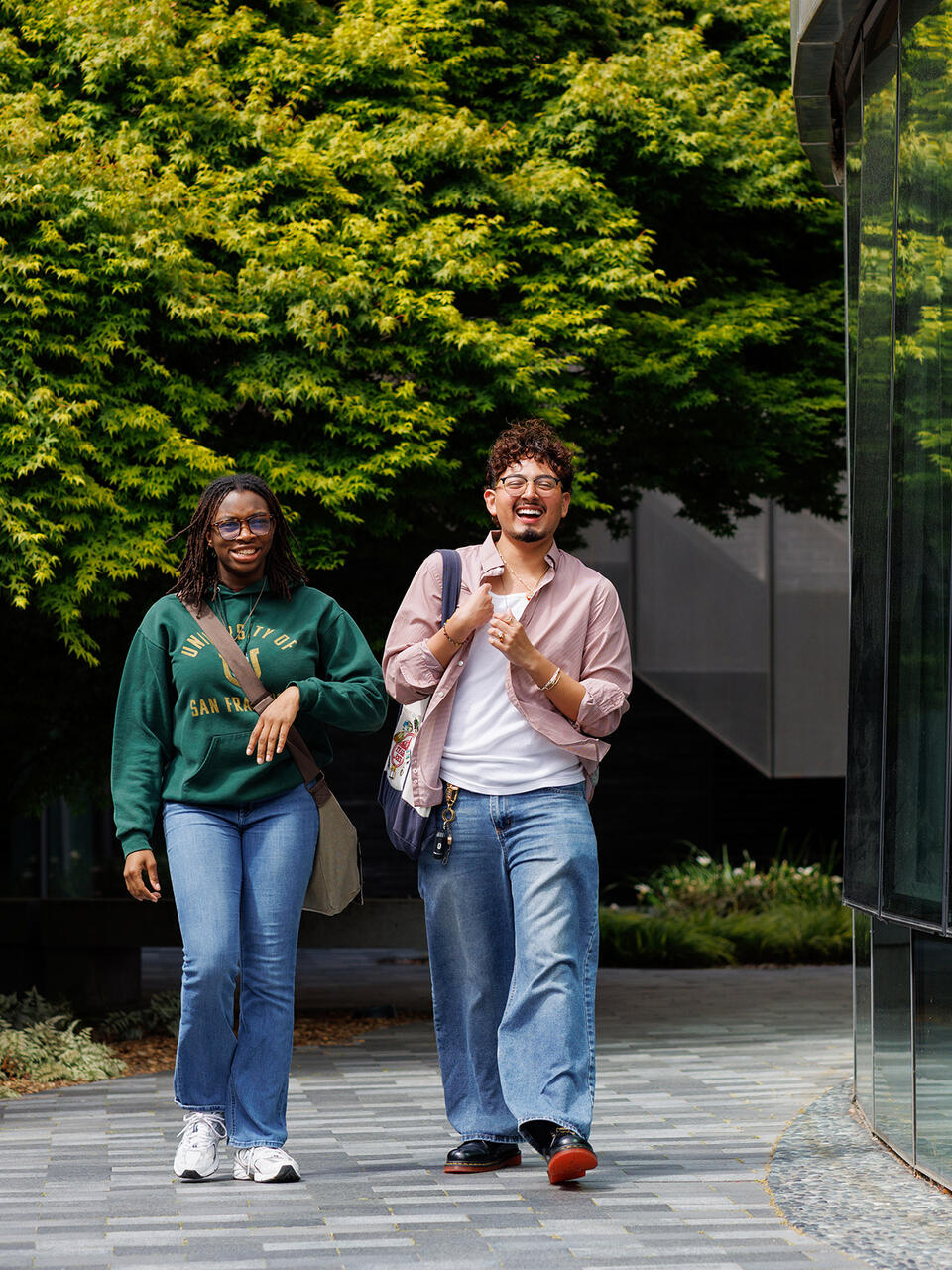 two students walk together outside on usf campus
